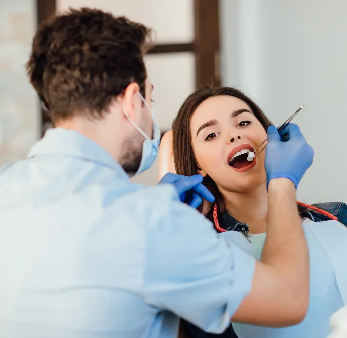 Dentist examining a smiling patient's teeth